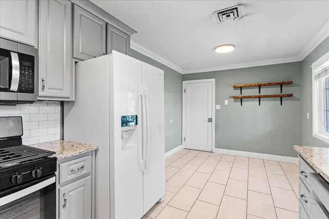 a kitchen with white cabinets and black appliances