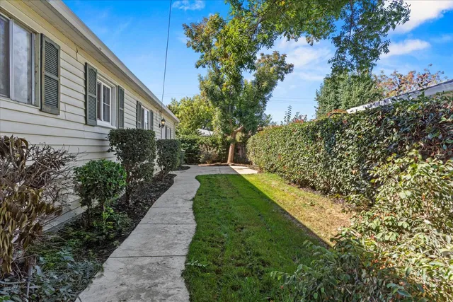 a view of house with a backyard and a garden