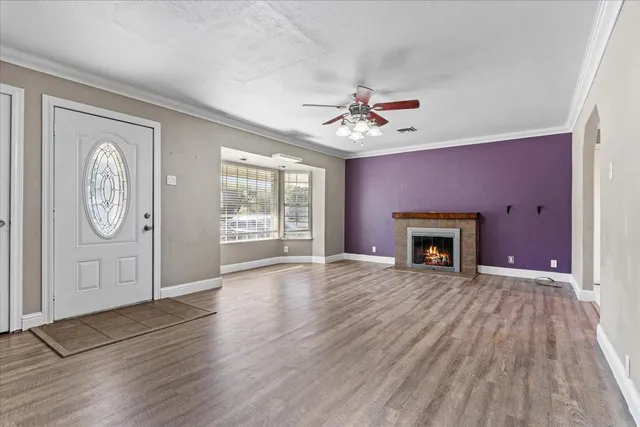 a view of an empty room with window wooden floor and a fireplace