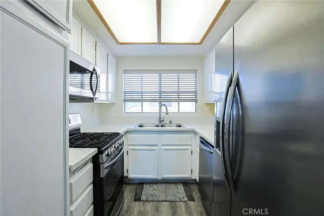 a kitchen that has a sink cabinets appliances and a window