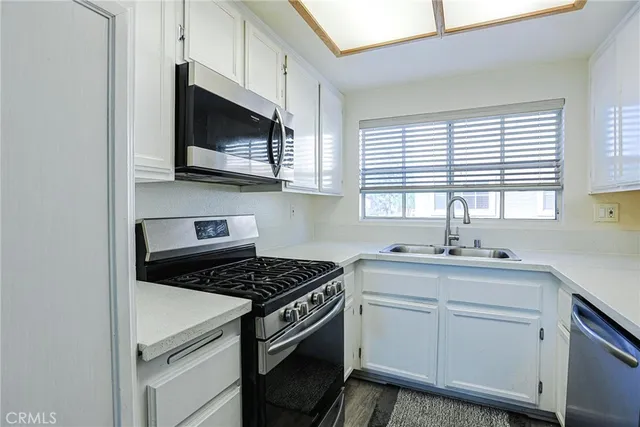 a kitchen with stainless steel appliances a sink stove and microwave