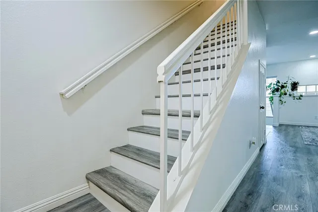 a view of staircase with wooden floor and white walls