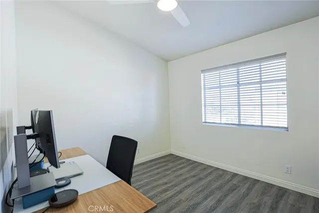 a view of a workspace with furniture and a window