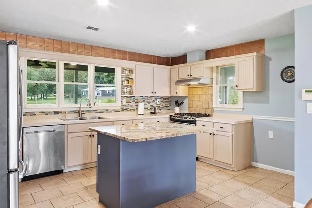 a kitchen with stainless steel appliances granite countertop a sink stove and refrigerator