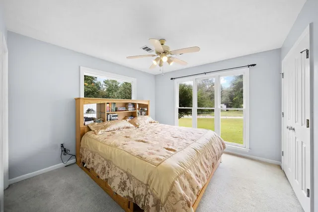 a bed sitting in a spacious bedroom next to a window