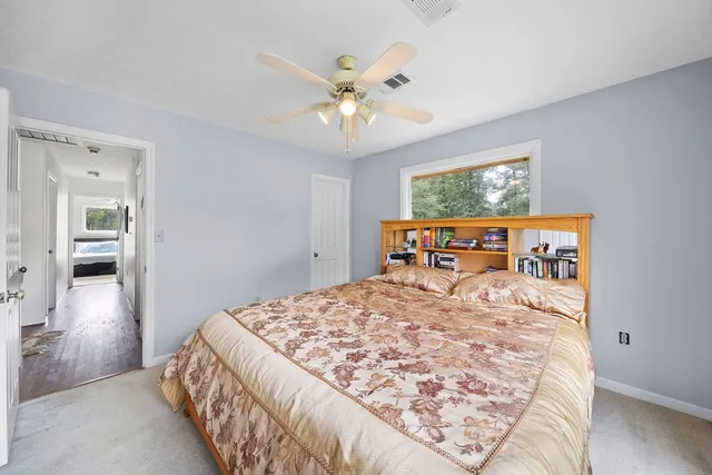 a bed sitting in a bedroom and chandelier