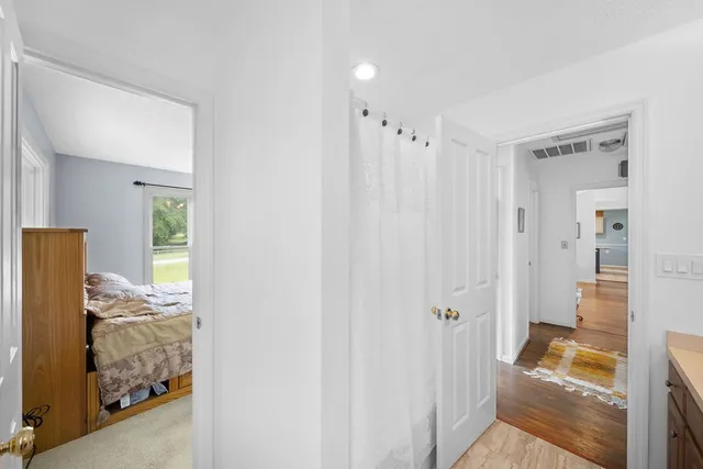 a view of a bedroom with wooden floor and windows