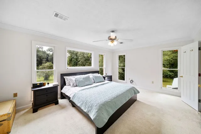 a bedroom with a large bed and a chandelier fan