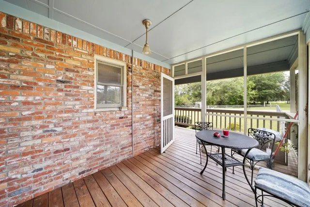 a balcony with wooden floor and outdoor seating