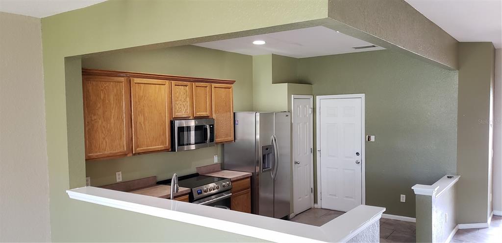 4245 Southwest 50th Circle Ocala, FL 34474 - Photo 2 of 14 a kitchen with a refrigerator and a sink