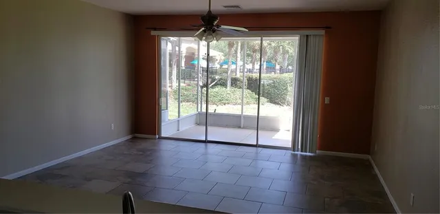 a view of an empty room with glass door and windows