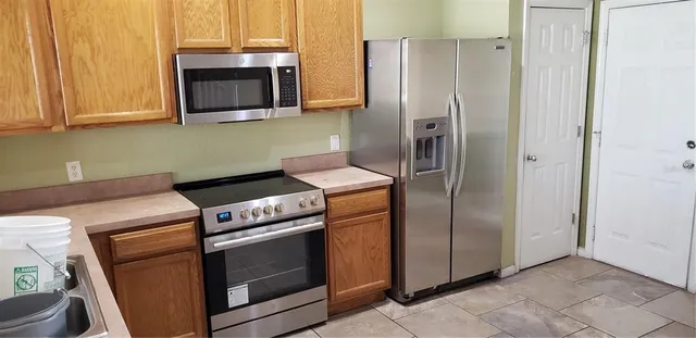 a kitchen with stainless steel appliances granite countertop white cabinets a refrigerator and a stove