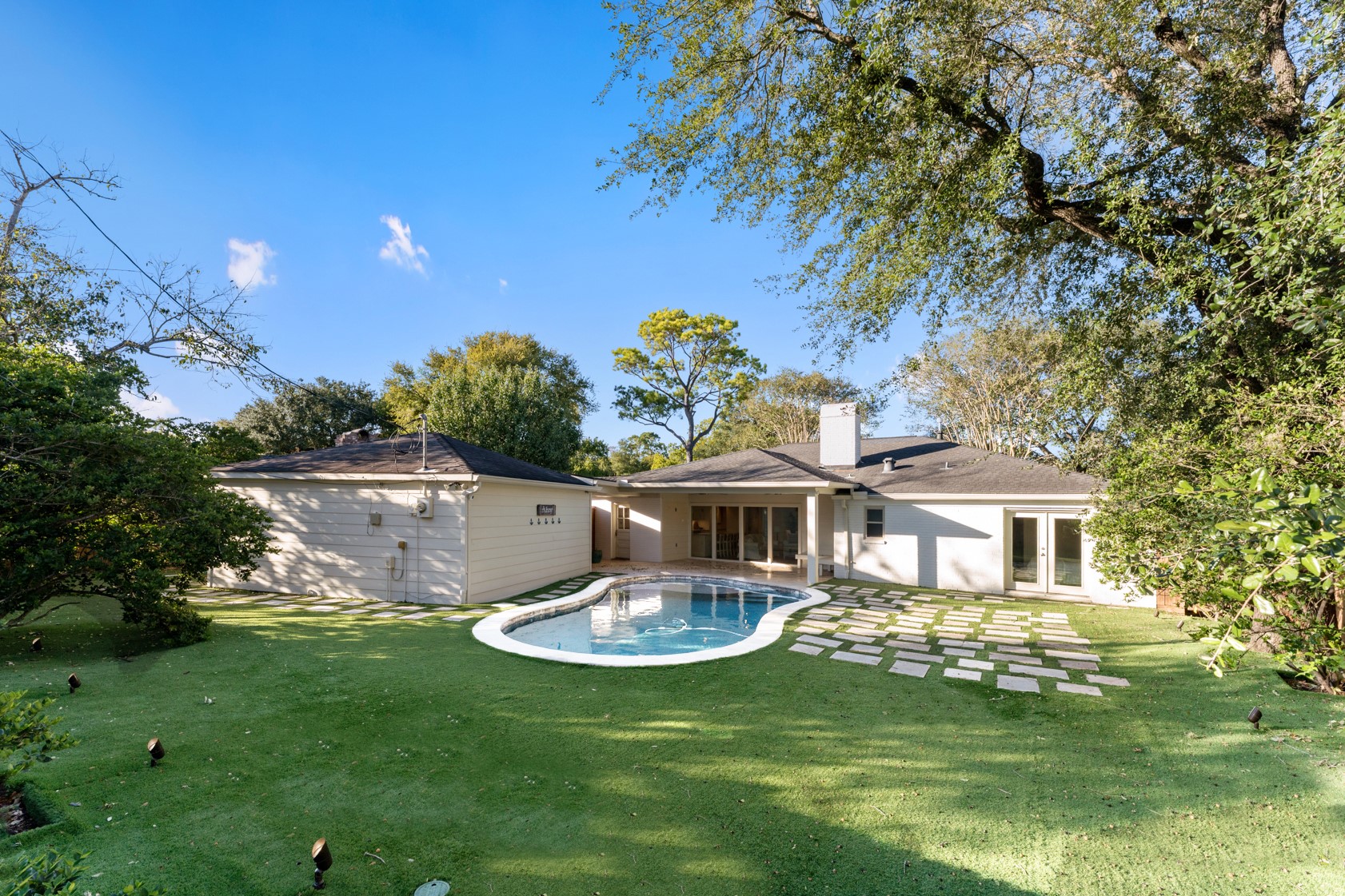 10703 Deerwood Road Houston, TX 77042 - Photo 11 of 28 The amazing, fenced-in backyard is complete with turf, pool, pavers, and a covered outdoor living space with ceiling fans.