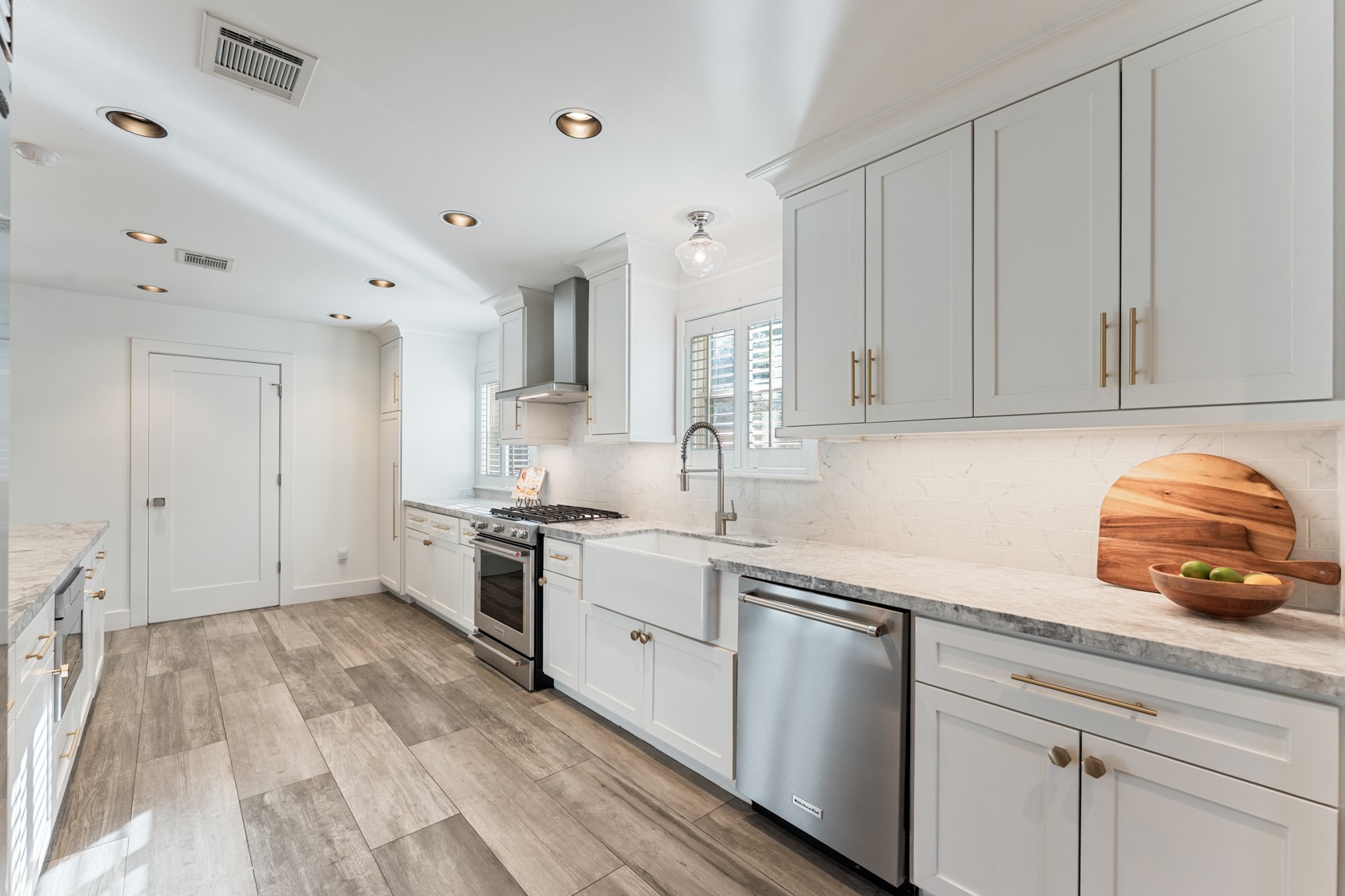 10703 Deerwood Road Houston, TX 77042 - Photo 16 of 28 Perspective of the kitchen showing the soft-closing cabinets and drawers, farmhouse sink, and no shortage of prep space.