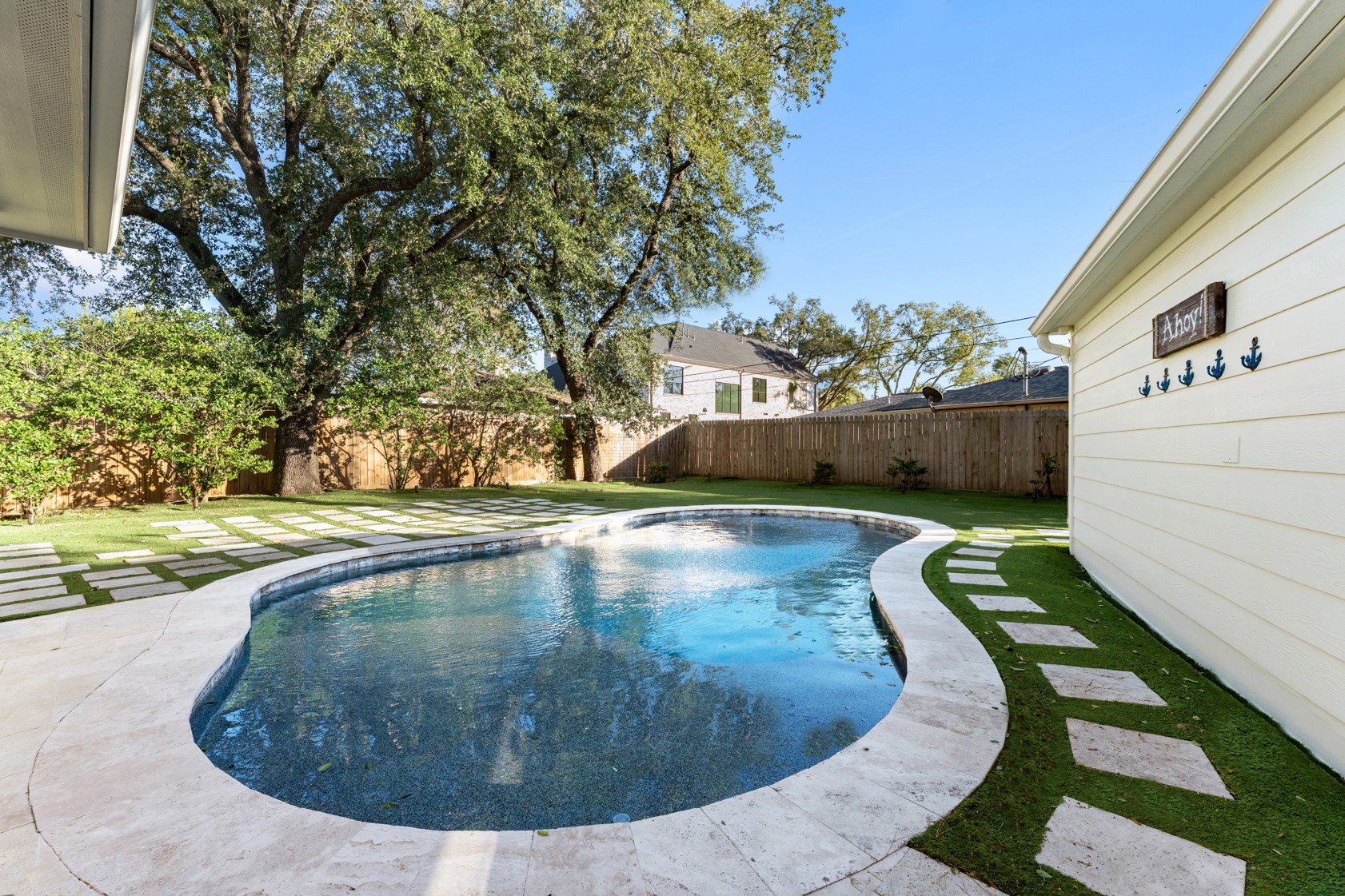 10703 Deerwood Road Houston, TX 77042 - Photo 20 of 28 The sparkling pool with a ledge is ideal for warm days, complemented by abundant green space for play and relaxation.