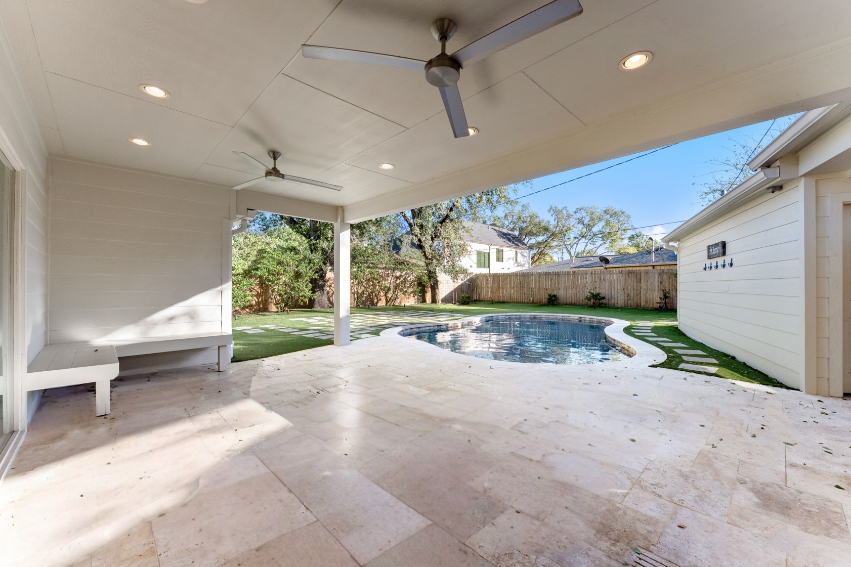 10703 Deerwood Road Houston, TX 77042 - Photo 4 of 28 Beautiful covered patio with two ceiling fans and recessed lighting. Enjoy comfortable outdoor living with views of the sparkling pool and turfed backyard.
