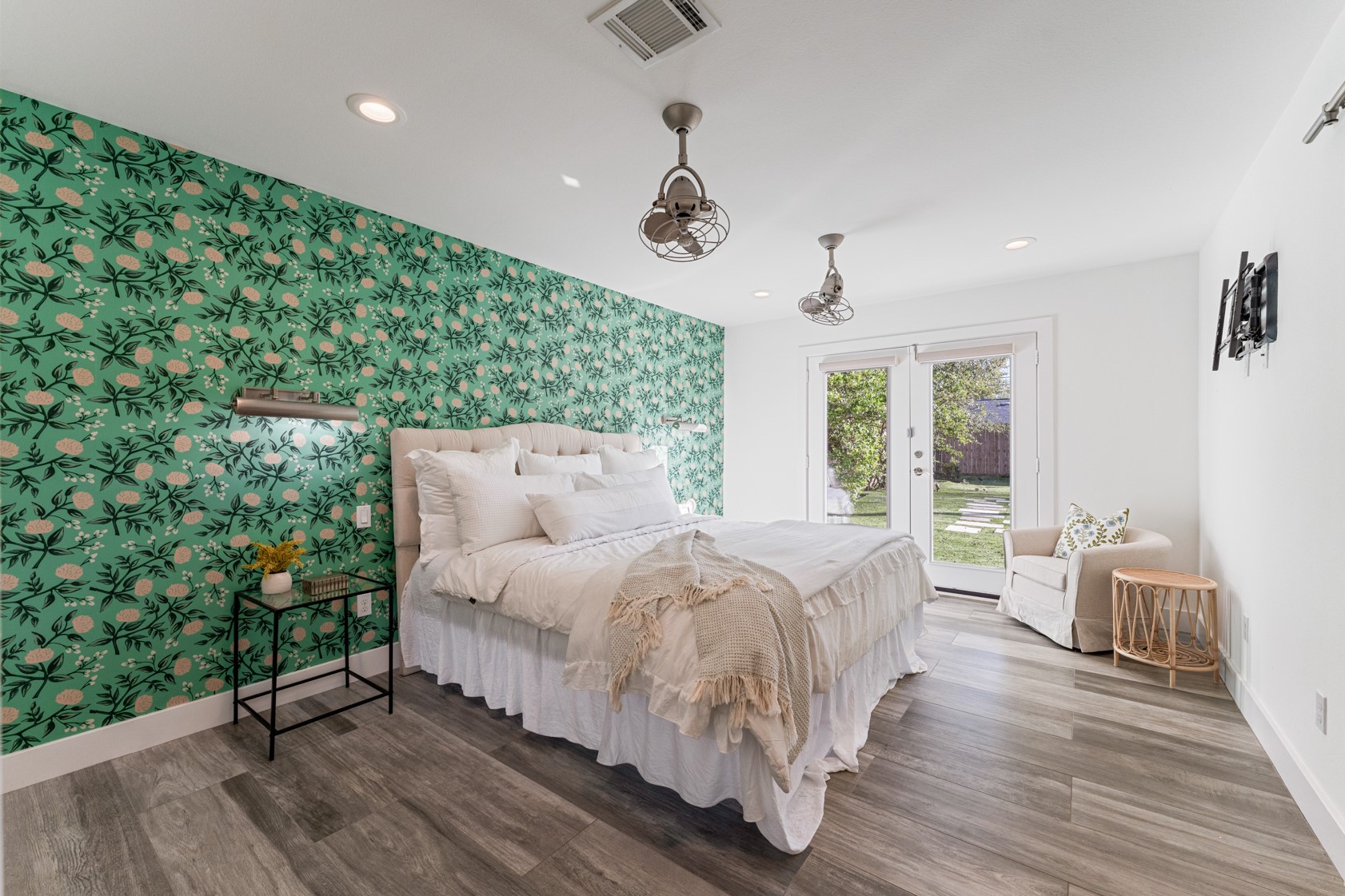 10703 Deerwood Road Houston, TX 77042 - Photo 8 of 28 Primary suite featuring designer wallpaper, specialty wall sconces, and elegant French doors that open to the expansive backyard.