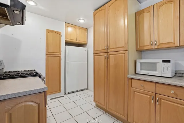 a kitchen with stainless steel appliances granite countertop a refrigerator a stove and a sink