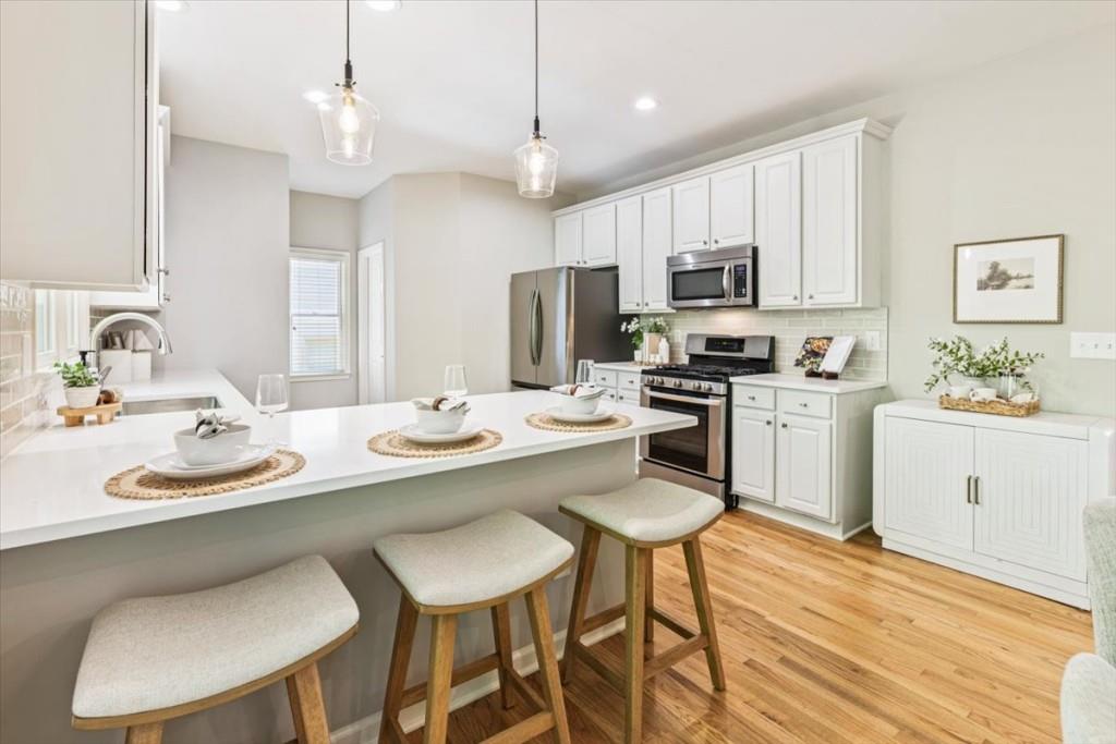 1110 Compass Pointe Crossing Alpharetta, GA 30005 - Photo 22 of 55 a kitchen with stainless steel appliances kitchen island granite countertop a sink a stove a table and chairs