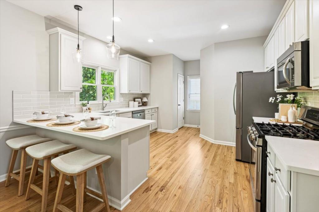 1110 Compass Pointe Crossing Alpharetta, GA 30005 - Photo 23 of 55 a kitchen with stainless steel appliances a sink stove refrigerator and chairs