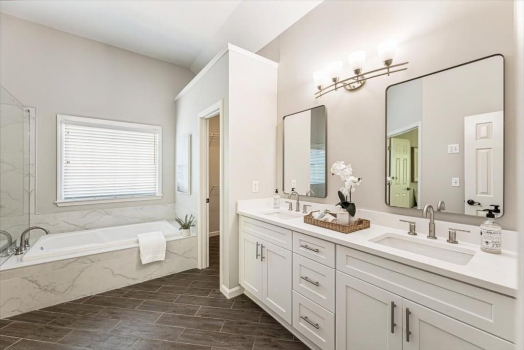 1110 Compass Pointe Crossing Alpharetta, GA 30005 - Photo 34 of 55 a bathroom with a double vanity sink a large mirror and a bathtub
