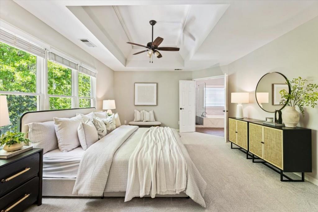 1110 Compass Pointe Crossing Alpharetta, GA 30005 - Photo 4 of 55 a spacious bedroom with a bed a mirror on dresser and a chandelier