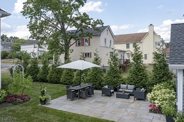 a view of backyard with outdoor seating barbeque oven and trees