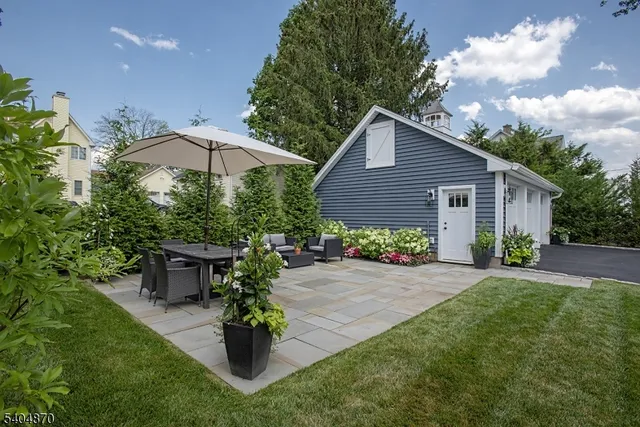 a view of a house with backyard sitting area and garden