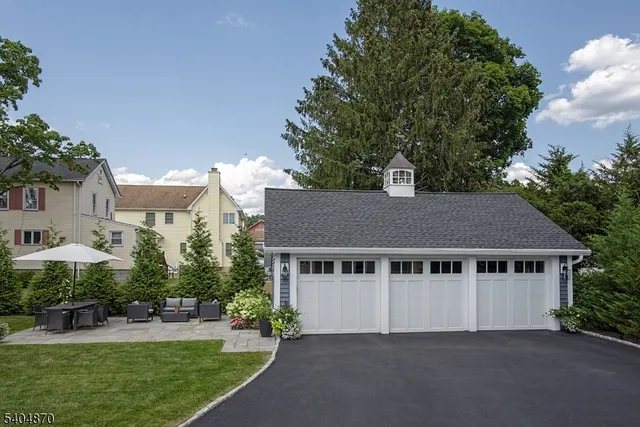 a aerial view of a house next to a yard and large trees