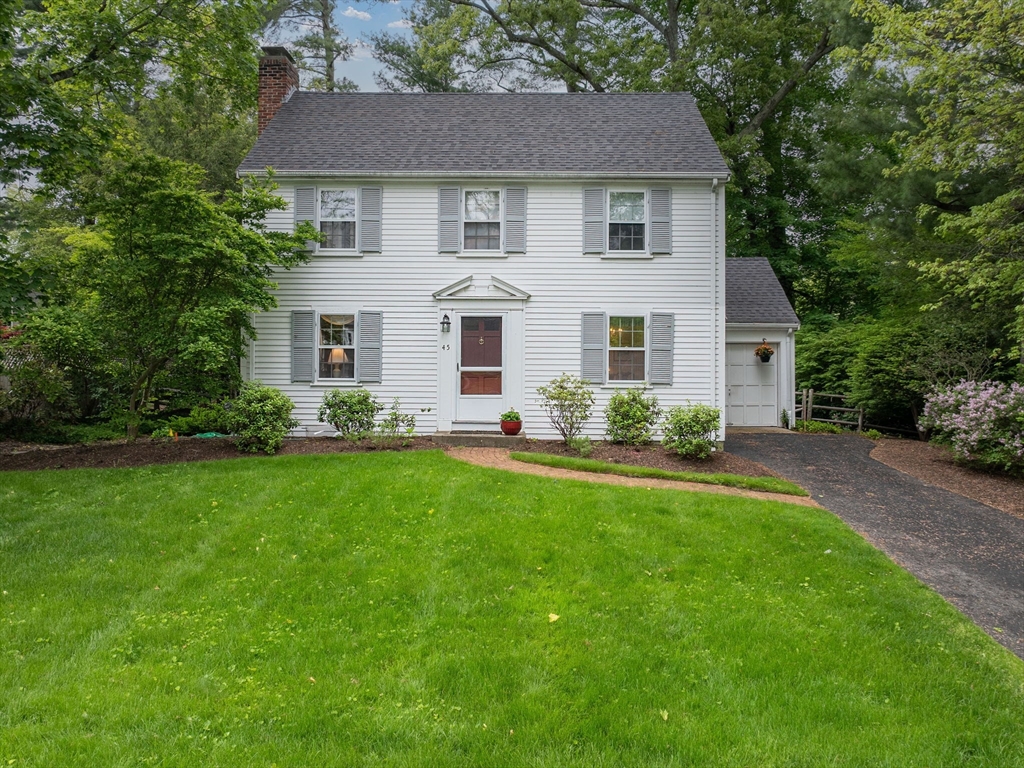 a front view of a house with a garden and plants
