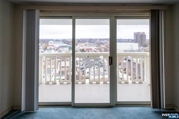 a view of a hallway with wooden floor and a living room