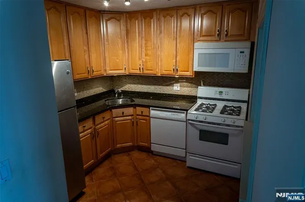 a kitchen with granite countertop a refrigerator and a stove
