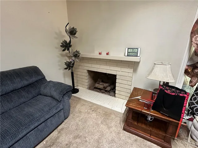 a living room with furniture a fireplace and a potted plant
