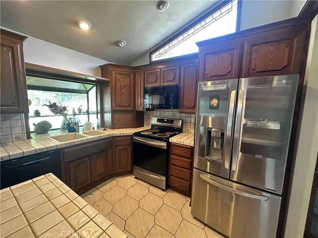 a kitchen with granite countertop a refrigerator and a sink