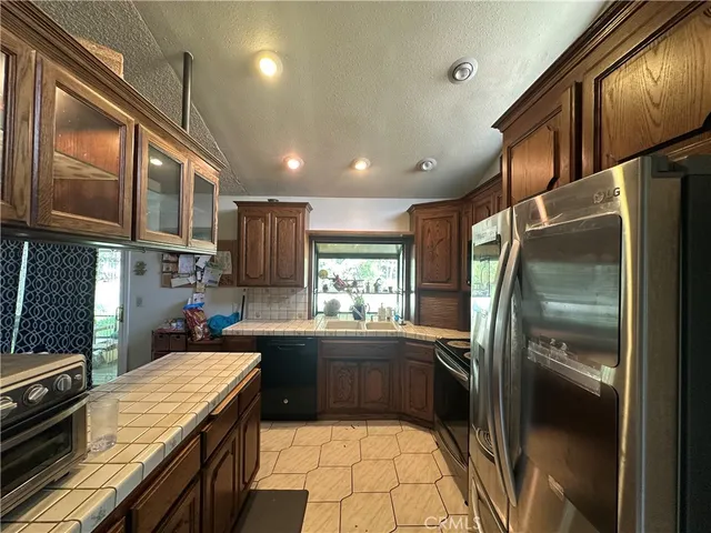 a kitchen with stainless steel appliances granite countertop a refrigerator a sink a stove and island
