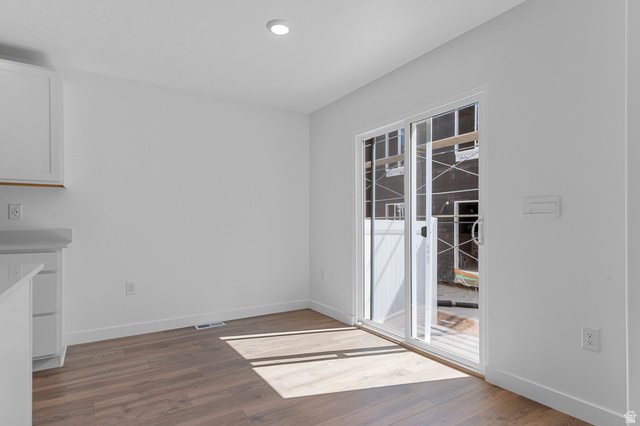 1907 East 640th North, Unit 1225 Salem, UT 84653 - Photo 18 of 20 Open-concept room featuring wood-finish flooring, white walls, and a sliding glass door