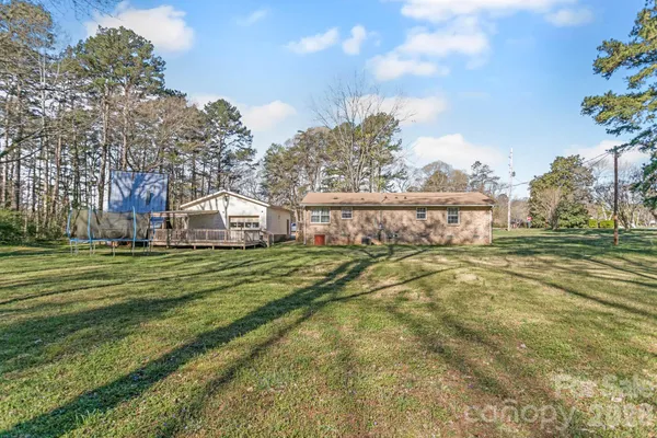 a view of a house with a big yard and large trees