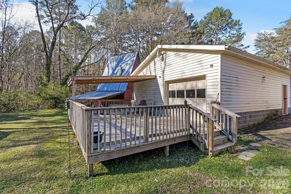 a view of a house with a wooden deck and a yard