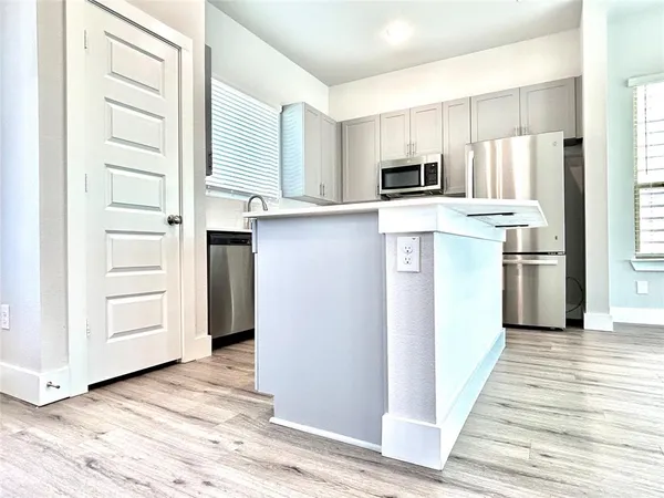 a kitchen with white cabinets and stainless steel appliances