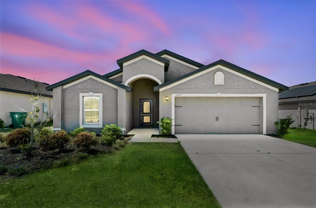 1729 Canaan Loop Dundee, FL 33838 - Photo 1 of 33 a front view of a house with a yard and garage