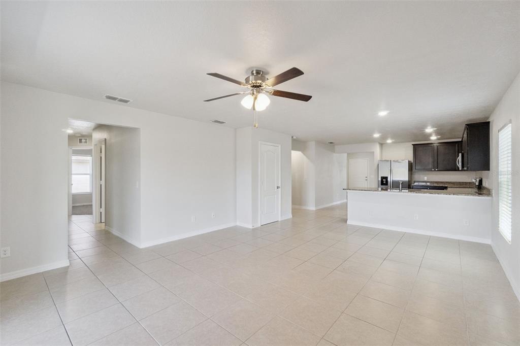 1729 Canaan Loop Dundee, FL 33838 - Photo 11 of 33 a view of an empty room and kitchen view with wooden floor
