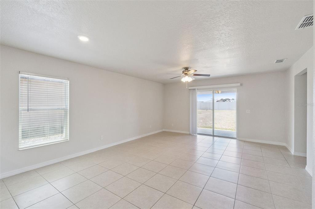 1729 Canaan Loop Dundee, FL 33838 - Photo 12 of 33 an empty room with chandelier fan and windows
