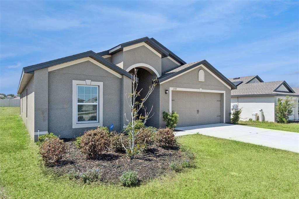 1729 Canaan Loop Dundee, FL 33838 - Photo 3 of 33 a front view of a house with a yard and garage