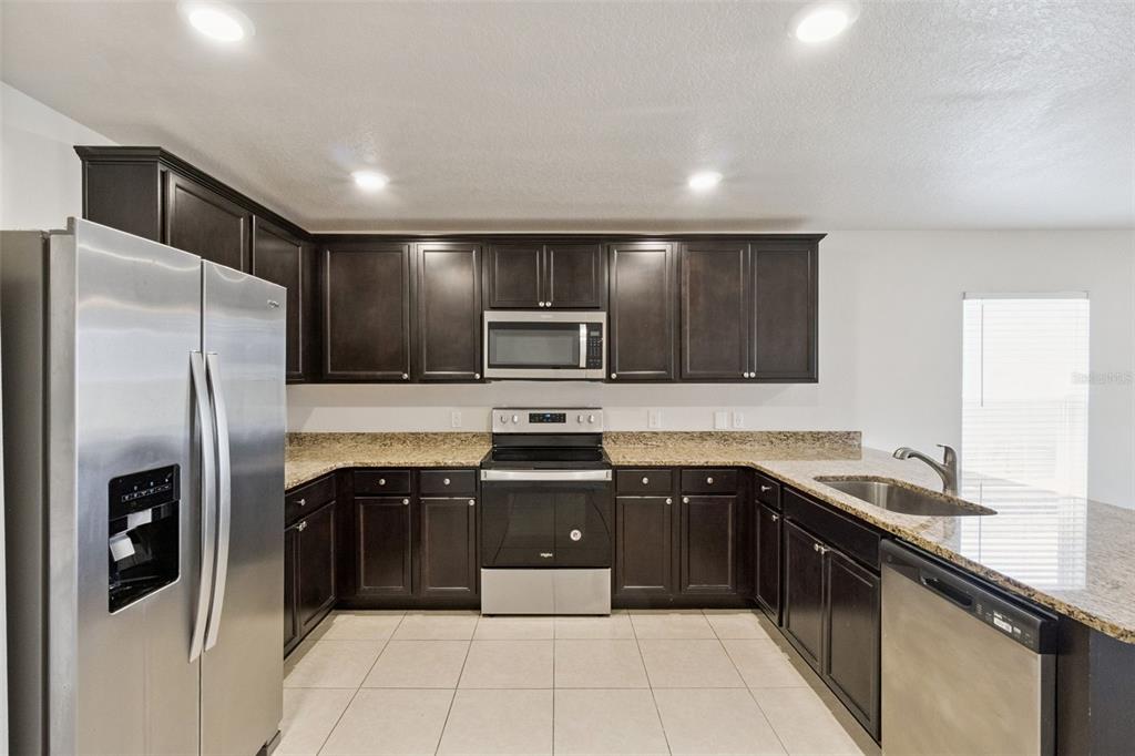 1729 Canaan Loop Dundee, FL 33838 - Photo 7 of 33 a kitchen with stainless steel appliances granite countertop a refrigerator and a sink