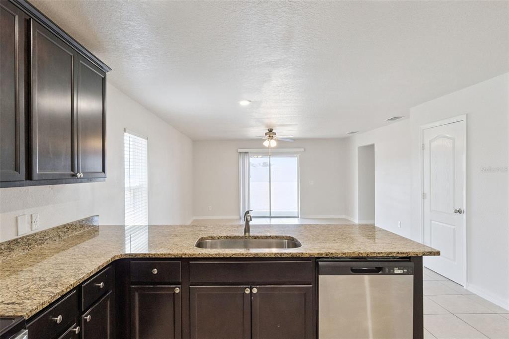 1729 Canaan Loop Dundee, FL 33838 - Photo 8 of 33 a kitchen with granite countertop stainless steel appliances sink and wooden floor