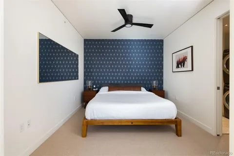 a bedroom with a bed and a painting on the wall