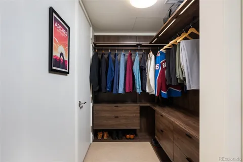 a view of walk in closet with clothes