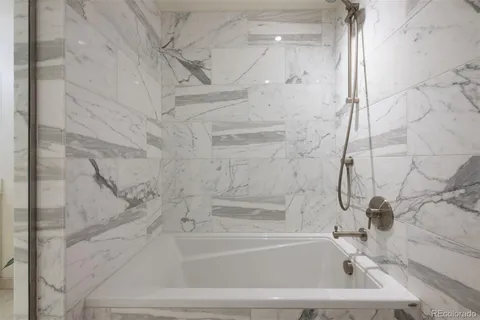 a bathroom with bathtub and shower