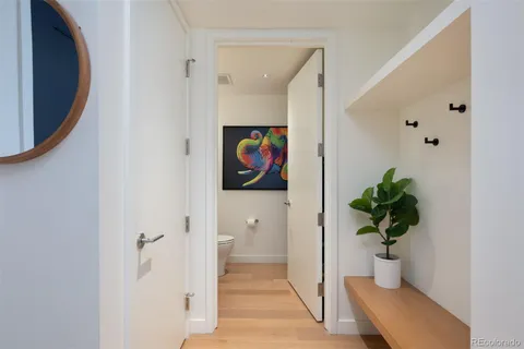 a view of a hallway with wooden floor and a potted plant