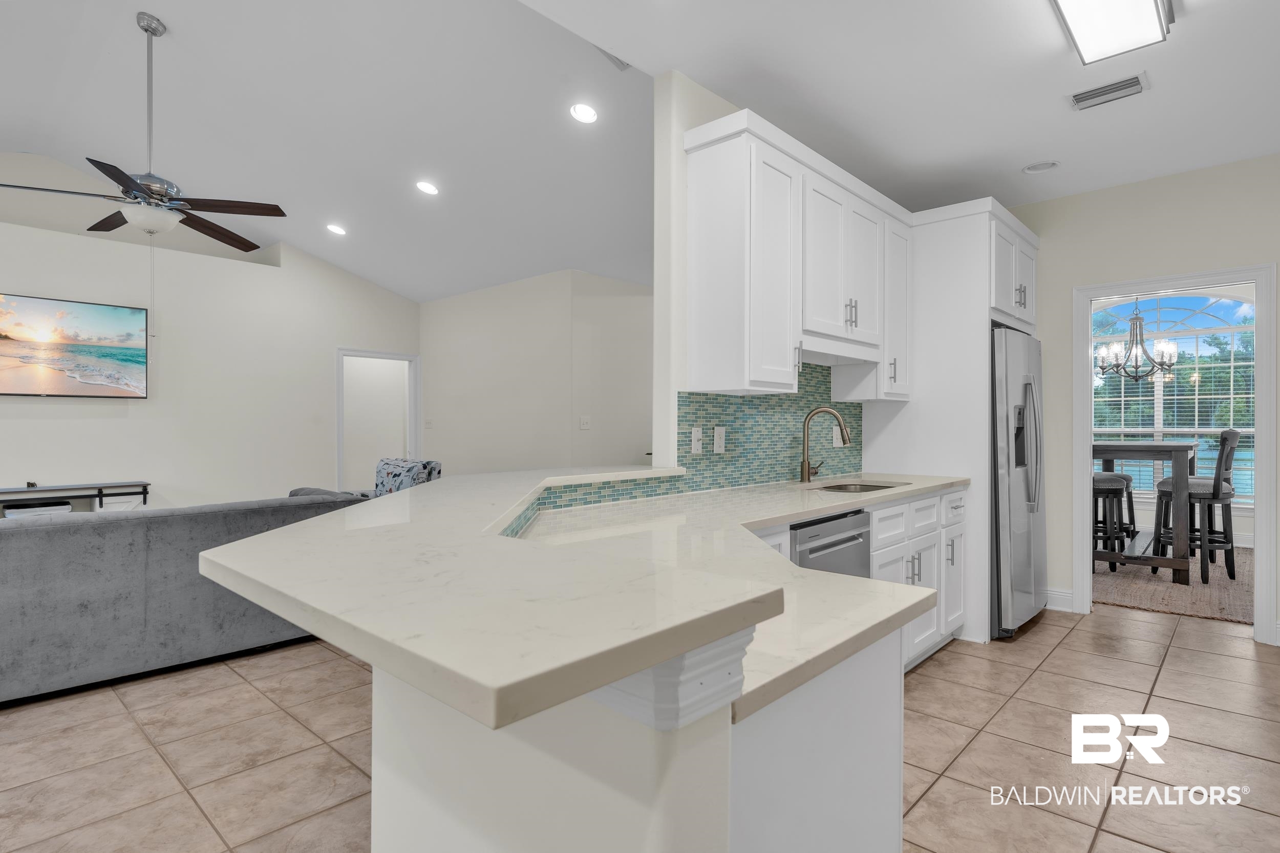 4606 Osprey Drive Orange Beach, AL 36561 - Photo 23 of 44 Kitchen with appliances with stainless steel finishes, a peninsula, light tile patterned floors, decorative backsplash, and recessed lighting